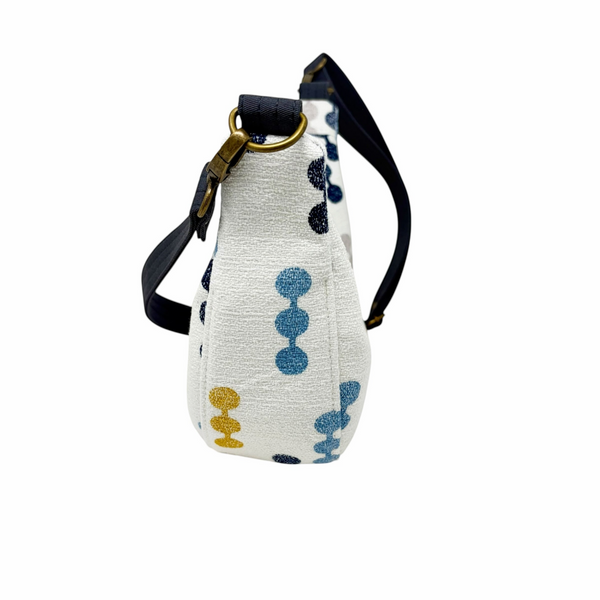 mmb by hand crescent crossbody bag in white textured fabric with navy, mustard, and grey geometric dot pattern