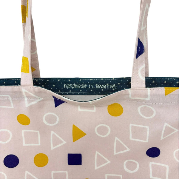 mmb by hand light pink fabric tote bag with yellow and navy geometric shapes and a navy star-patterned interior