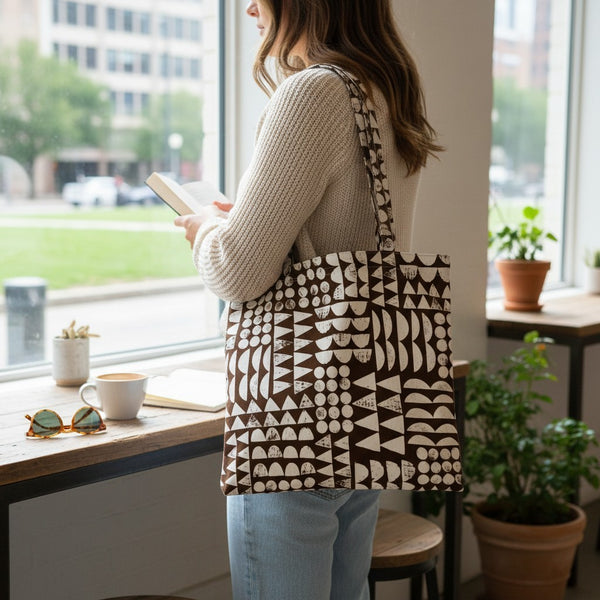 mmb by hand organic cotton tote bag with brown geometric print carried by a woman standing near a bright window